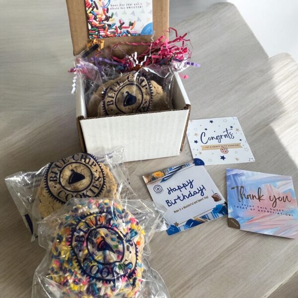 Assorted cookies with celebration cards on table