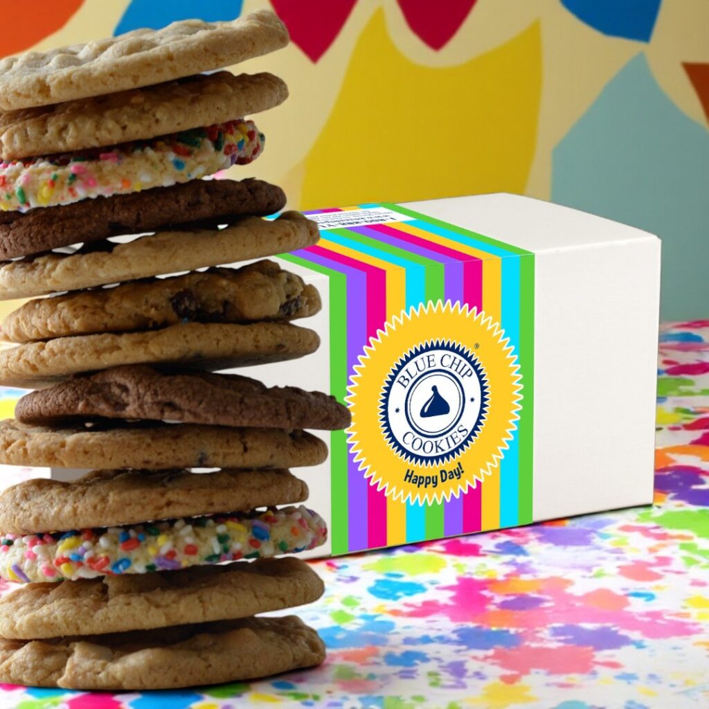 Stacked assorted cookies beside colorful cookie box