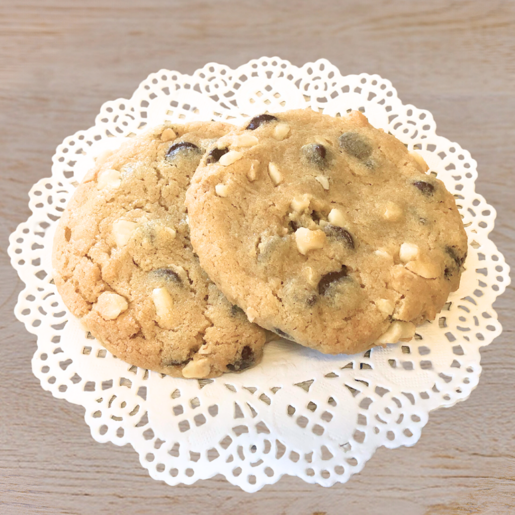 Two chocolate chip cookies on lace paper doily