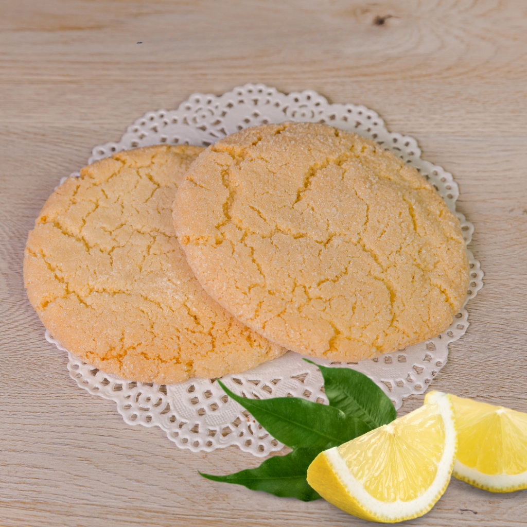 Two lemon cookies on lace doily with lemon slices