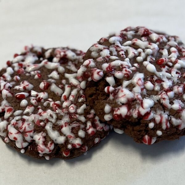 Chocolate cookies topped with white icing and candy cane bits