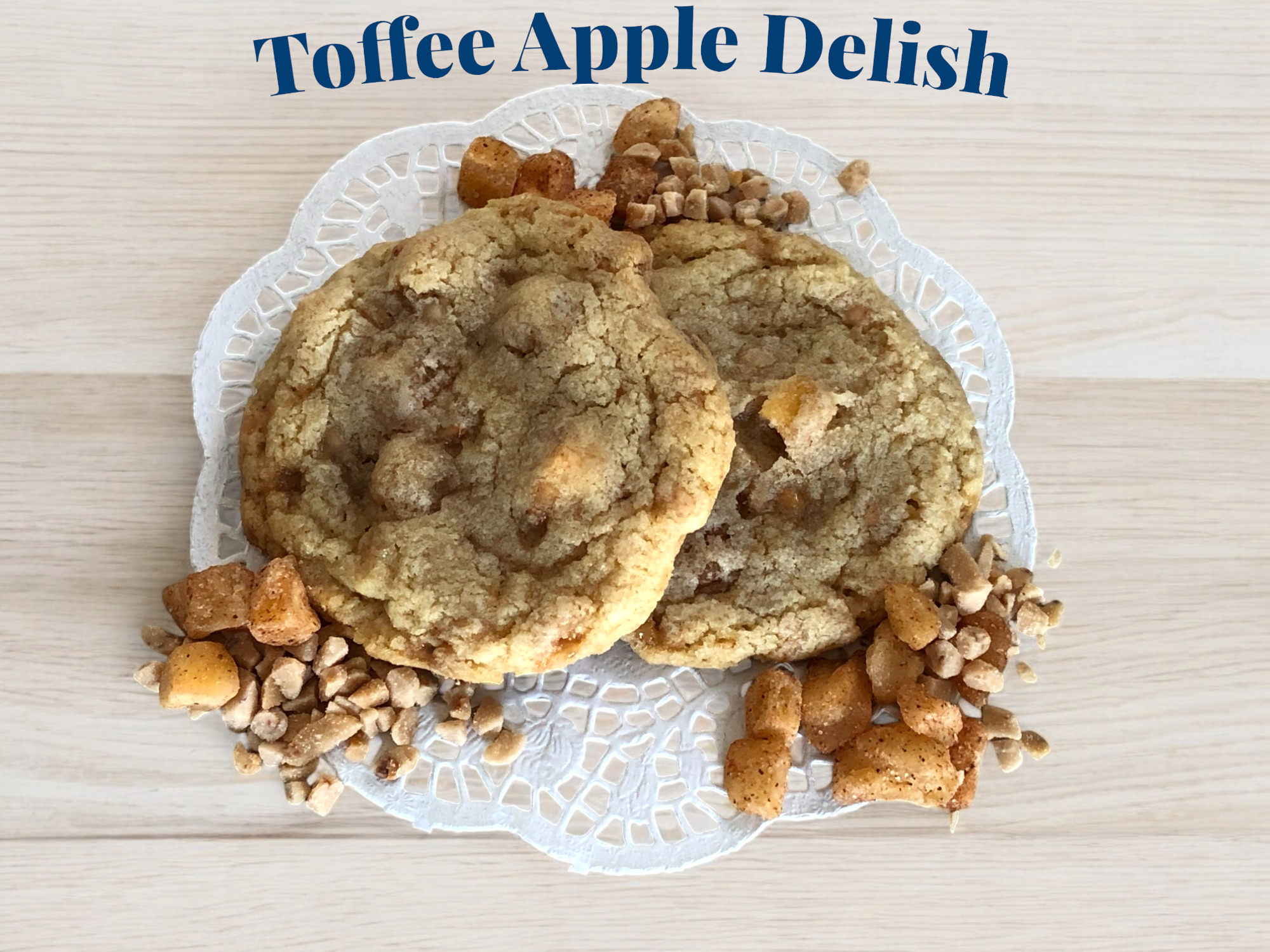 Toffee apple cookies on lace paper over wooden surface.