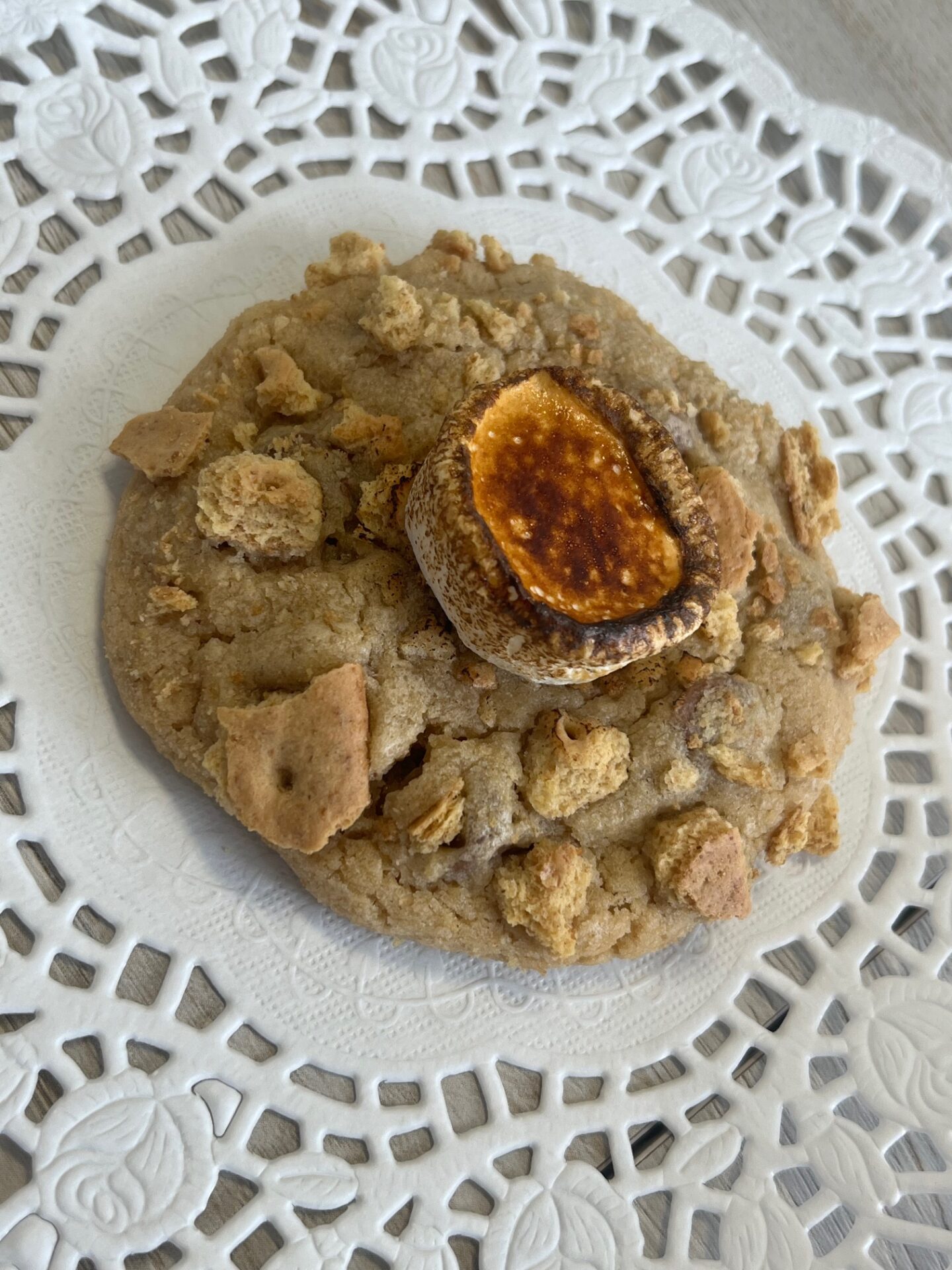 Cookie with marshmallow and cereal topping on lace plate